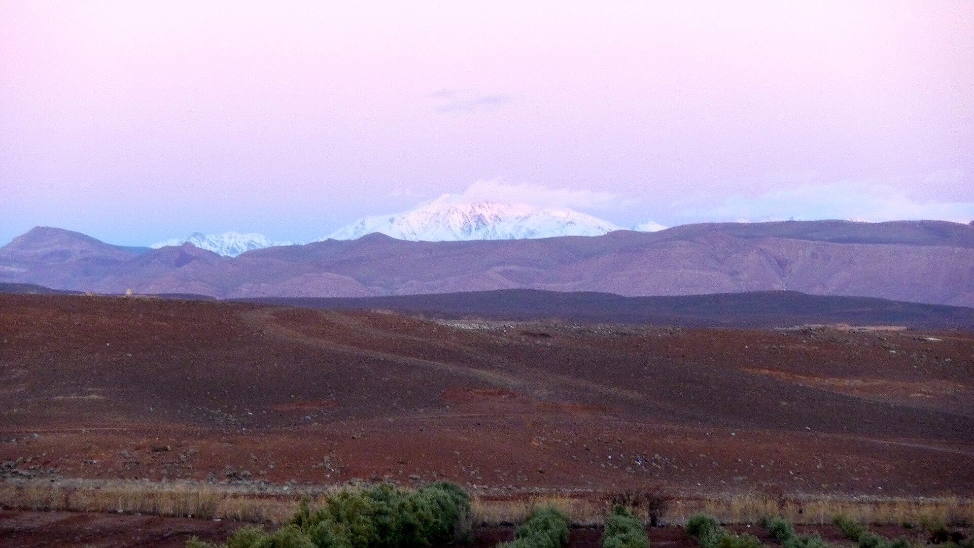 The High Atlas at first light, a pink sky over dark plains